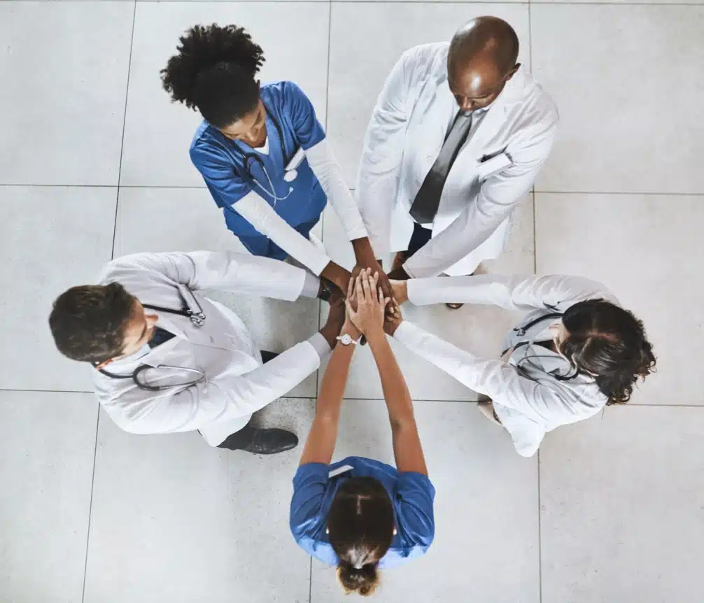 Healthcare team joining hands in a circle